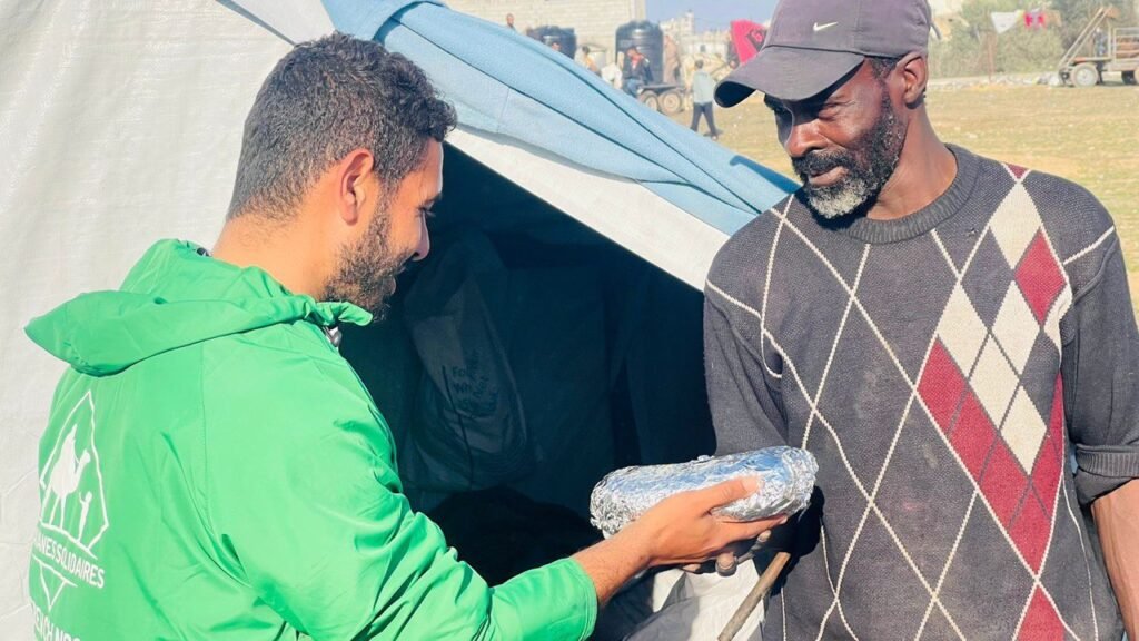 Photo d'un homme qui reçoit un repas lors de nos distributions à Gaza, dans les camps de réfugiés